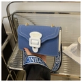 Detalle de bolso bandolera de lona azul con costuras blancas y correa ancha de moda - Azul