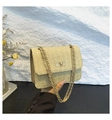 Detail of straw woven crossbody bag featuring golden chain strap and swivel lock - Khaki