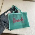 Minzgrüne Strandtasche aus Netzstoff mit rosa Beach Vibes Aufdruck und Tragegriffen - See-Blau mit rotem Text