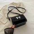 Crossbody black square bag featuring silver bow detail and mixed material texture - Black