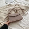 Beige woven crossbody bag with decorative knotted handle and elegant flap closure - Khaki