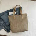 Borsa tote in paglia beige con manici in pelle PU marrone su sfondo di tessuto bianco - Cachi