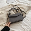 Dark grey textured crossbody bag with thick rope handle and golden metal hardware details - Black