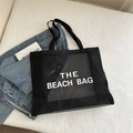 Black mesh beach bag tote featuring white THE BEACH BAG print and breathable nylon fabric - Black With White Lettering