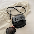 Bolso bandolera negro con doble hebilla y herrajes dorados sobre chaqueta americana - Negro