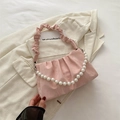 Pink pleated underarm bag featuring a lustrous satin texture and a large pearl handle - Pink