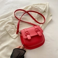 Bolso de montura rojo vibrante con hebillas dobles sobre fondo de blazer elegante - Rojo