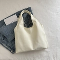 Minimalist cream white canvas tote bag shown in a flat lay style with denim and art book - Off White