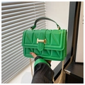 Detail of bright green quilted handbag featuring a gold buckle and metal chain strap - Green