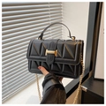 Close-up of black triangle-quilted leather handbag with a gold rectangular metal clasp - Black