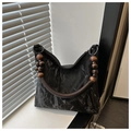 Détail du sac plissé noir montrant les perles en bois et la texture de la bandoulière - Noir