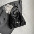 Borsa tote nera a pieghe con catena a farfalla argentata su un blazer grigio scuro - Nero
