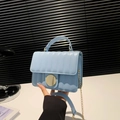 Baby blue striped quilted crossbody bag with a large gold round buckle and chain strap - Blue