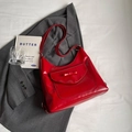 Borsa tote rosso lucido con fiocco decorativo e tracolla su un abito grigio - Standard / Borgogna