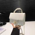 Sac bandoulière crème à rayures matelassées avec chaîne dorée sur un podium blanc - Blanc