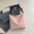 Pink pleated shoulder bag with dark wooden beaded strap and glossy synthetic leather finish - Pink