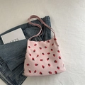 Pink corduroy tote bag with strawberry print shown on denim for casual lifestyle look - Pink