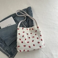 White corduroy bucket bag with strawberry embroidery and a slim shoulder strap - White