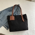 Détail du cabas en toile noire avec poignées en cuir marron et boucles argentées réglables - Noir