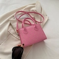 Pink quilted crossbody bag with golden heart studs on elegant beige background - Pink