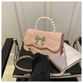 Detail showing pink bag with marble texture, pearl handle and silver bow decoration - Pink