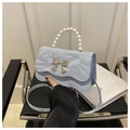 Dettaglio borsa azzurra con manico di perle e chiusura a farfalla in argento lucido - Blu