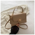 Detail der beigen Box-Tasche mit goldenem Rundschloss und glattem, mattem Leder-Finish - Khaki