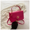 Detailed view of the rose red box bag with gold circular lock and textured leather - Rose Pink