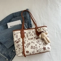 Borsa tote bianca con graffiti, finiture in pelle marrone e charm a orsetto - Con Ornamento / Marrone
