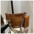 Brown vintage tote bag detail showing textured leather and geometric woven strap - Tan