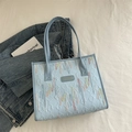 Light blue tote bag featuring wavy colorful embroidery and textured fabric design - Blue