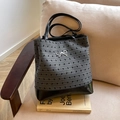 Polka dot gray and black tote bag with silver bow accent on a cozy sofa - Bowknot Without Charm