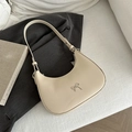 Chic beige hobo underarm bag with silver bow accent on a dark grey blazer - White