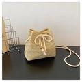 Detailed view of woven straw bucket bag with cotton drawstring and wooden beads - Khaki
