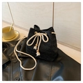 Close-up of black woven bucket bag showing V-pattern texture and cream drawstring detail - Black
