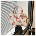 Detail der weißen Handtasche aus Saffiano-Leder mit roten Schmetterling- und Sternprints - Rot