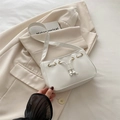 Borsa baguette bianca minimalista con coulisse e occhielli dorati su blazer - Bianco