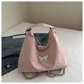 Detailed shot of pink tote bag with large silver butterfly ornament and metal chain - Pink