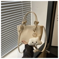 Détail d'un sac seau blanc crème avec texture litchi et un charmant nuage en peluche - Blanc cassé avec pendentif