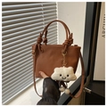 Brown lychee texture bucket bag with knotted handles and a plush cloud charm accessory - Brown with Pendant
