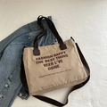 Minimalist beige canvas tote bag with dark brown handles and letter print on textured fabric - Khaki