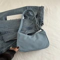 Bolso hobo de mezclilla azul claro con diseño minimalista sobre fondo blanco - Azul