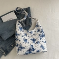 White hobo tote bag with blue butterfly and star prints featuring a wide shoulder strap - Blue