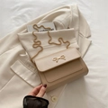 Beigefarbene minimalistische Klappentasche mit goldener Schleife und strukturierter Kette - Khaki