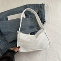 Minimalist white canvas hobo bag with top zipper on denim jacket background - White