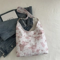 White hobo shoulder bag with pink butterfly print and gold hardware on denim background - Pink