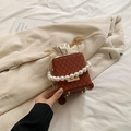 Caramel woven crossbody bag featuring a large pearl handle and golden chain strap - Brown