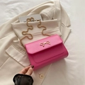 Minimalistische rosa quadratische Unterarmtasche mit goldener Schleife und Kette - Rosenrosa