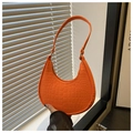 Primer plano de bolso hobo naranja brillante con textura de cocodrilo y asa ancha de moda - Naranja