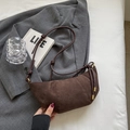 Dark brown suede croissant crossbody bag with knot strap detail on a grey blazer - Dark Coffee